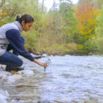 Female biologist testing the oxygen levels in the river