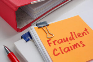 A stack of papers labeled fraudulent claims. Insurance fraud and legal investigation.